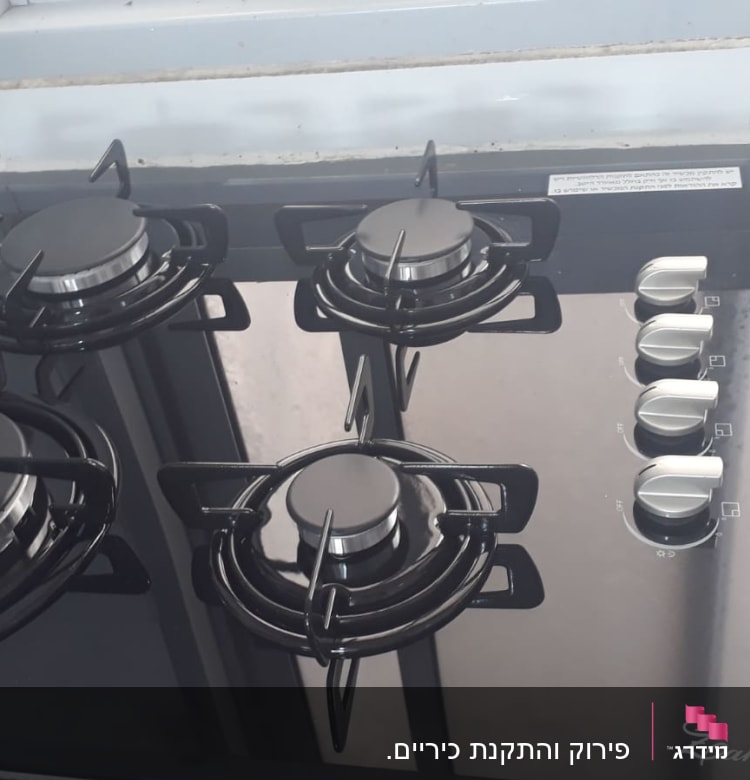 כיריים גז עם ארבעה מבערים וכפתורי שליטה